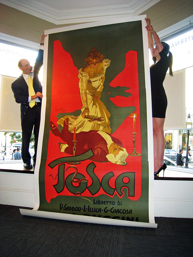 Gallery staff hold up the rare 10 foot tall original TOSCA opera poster from 1899.